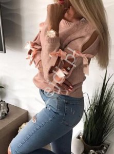 Jasno różowy sweterek z rozcięciami na rękawach, zdobiony kokardkami