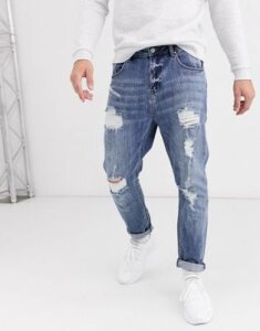 ASOS DESIGN tapered jeans in mid wash blue with heavy rips